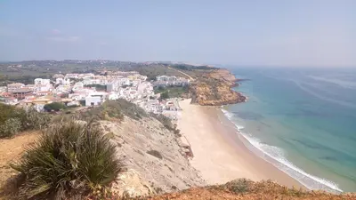 a view of a beach with houses on a cliff at Apartamento Amalita em Burgau in Burgau