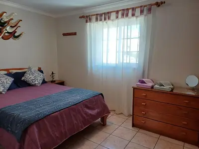 a bedroom with a bed and a dresser and a window at Apartamento Amalita em Burgau in Burgau
