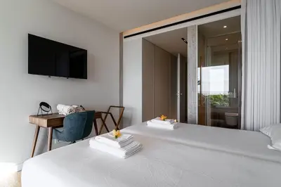 a bedroom with two beds with a television on the wall at Savoy Residence Monumentalis N&N by LM&AC Signature in Funchal