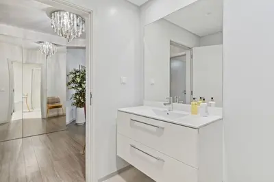 a white bathroom with a sink and a mirror at Indigo Apartment By The Madeira Luxury Collection in Funchal