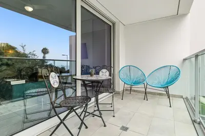 a patio with three chairs and a table on a balcony at Indigo Apartment By The Madeira Luxury Collection in Funchal