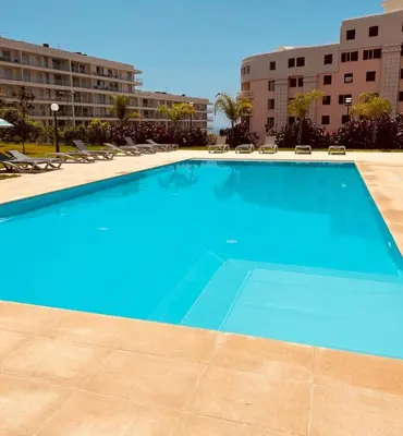 a large blue swimming pool in a resort at Indigo Apartment By The Madeira Luxury Collection in Funchal