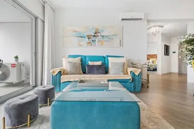 a living room with a blue couch and chairs at Indigo Apartment By The Madeira Luxury Collection in Funchal