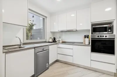 a white kitchen with white cabinets and appliances at Indigo Apartment By The Madeira Luxury Collection in Funchal