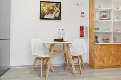 a table and two white chairs in a room at Indigo Apartment By The Madeira Luxury Collection in Funchal