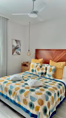 a bedroom with a large bed with a colorful comforter at Indigo Apartment By The Madeira Luxury Collection in Funchal