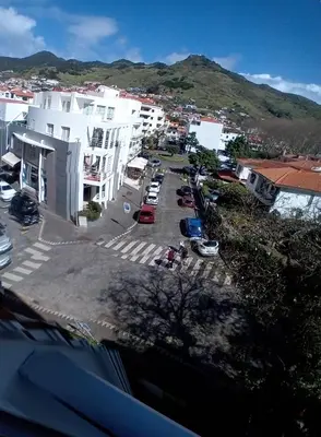 a city with cars parked in a parking lot at apartamento Zarco in Machico