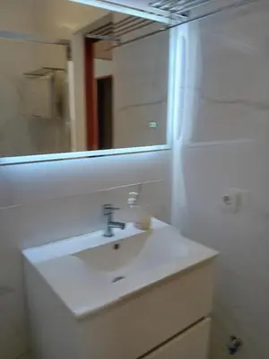 a bathroom with a white sink and a mirror at apartamento Zarco in Machico