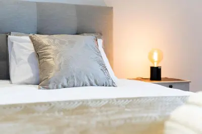 a bed with a pillow and a lamp on a night stand at A lovely home in a quiet area in Quinta Grande