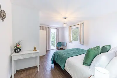 a white bedroom with a bed and a table at Recanto do Caminheiro by YOUR KEY in Santana