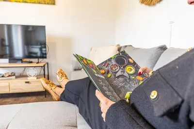 a person sitting on a couch reading a book at Recanto do Caminheiro by YOUR KEY in Santana