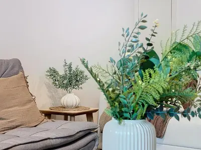 a white vase with plants on a table next to a couch at Acanto Loft by Atlantic Holiday in Funchal