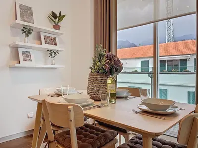a dining room with a wooden table and a window at Acanto Loft by Atlantic Holiday in Funchal