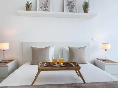 a tray of food on a bed with two glasses of orange juice at Acanto Loft by Atlantic Holiday in Funchal