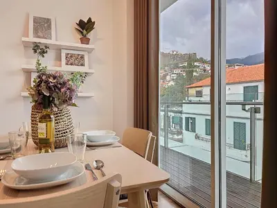 a dining room table with a view of a balcony at Acanto Loft by Atlantic Holiday in Funchal