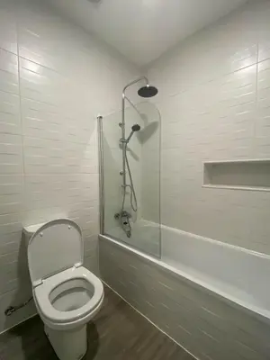 a bathroom with a toilet and a glass shower at Village Square Coastal Apartment 1D in Machico