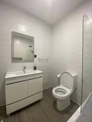 a bathroom with a toilet and a sink and a mirror at Village Square Coastal Apartment 1D in Machico