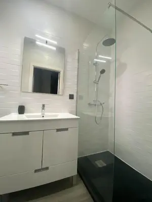 a white bathroom with a sink and a shower at Village Square Coastal Apartment 1D in Machico