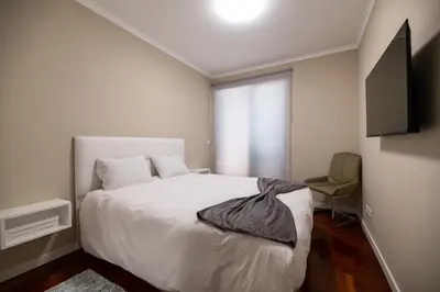 a bedroom with a white bed and a window at Garajau Terrace Atlântico in Garajau