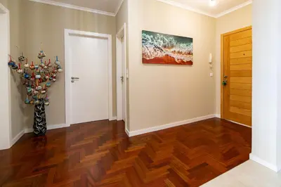 a living room with a wooden floor and a door at Garajau Terrace Atlântico in Garajau