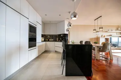 a kitchen with white cabinets and a black counter top at Garajau Terrace Atlântico in Garajau