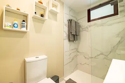 a bathroom with a toilet and a glass shower at Garajau Terrace Atlântico in Garajau