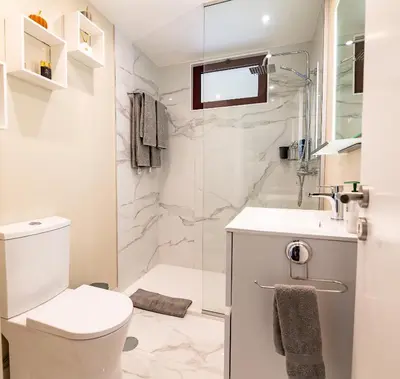 a white bathroom with a toilet and a sink at Garajau Terrace Atlântico in Garajau