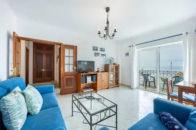 a living room with a blue couch and a table at Luz Heaven - Top floor Seaview Apartment in Luz