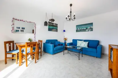 a living room with a blue couch and a table at Luz Heaven - Top floor Seaview Apartment in Luz