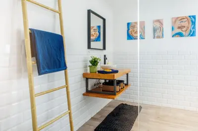 a bathroom with a ladder shelf and a mirror at Casa da Vila Apartments in Arco da Calheta