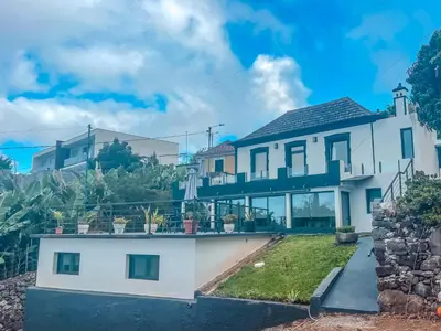 a large white house with a balcony at Casa da Vila Apartments in Arco da Calheta