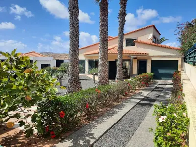 a house with palm trees in front of a driveway at Heritage Villa Porto Santo in Porto Santo