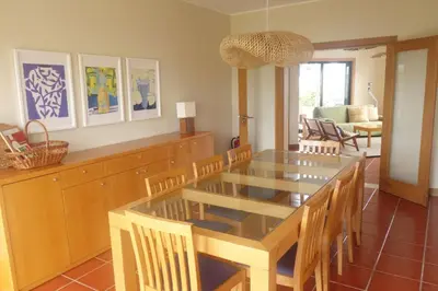 a book shelf filled with books and remote controls at Heritage Villa Porto Santo in Porto Santo