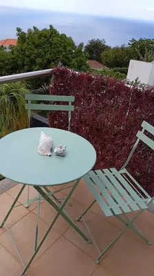 a white table and a chair and a table and a table and chairs at Bugio Guesthouse in Santa Cruz