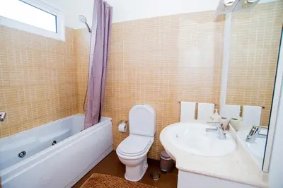 a bathroom with a toilet and a tub and a sink at Bugio Guesthouse in Santa Cruz