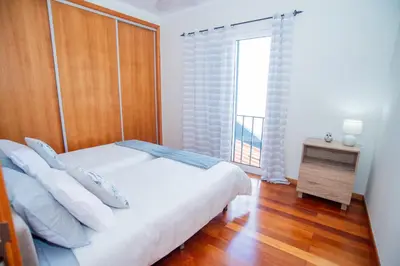 a bedroom with a large bed with a purple rug at Bugio Guesthouse in Santa Cruz