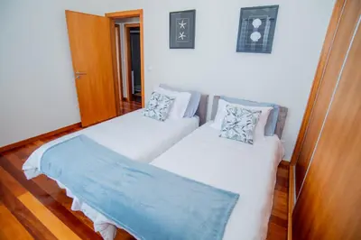 a bedroom with a purple rug and a bed and a window at Bugio Guesthouse in Santa Cruz