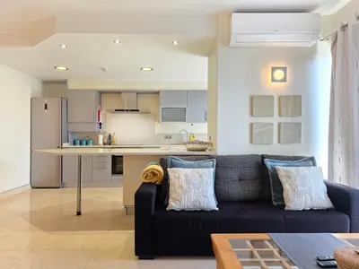 a living room with a couch and a kitchen at Fórum Madeira Residence in Funchal
