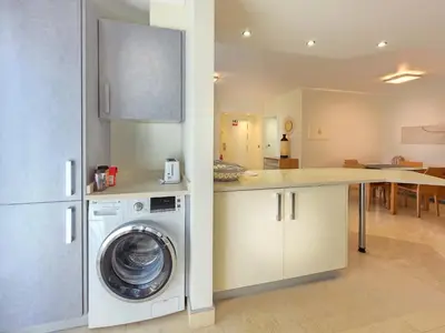 a kitchen with a washing machine in a kitchen at Fórum Madeira Residence in Funchal