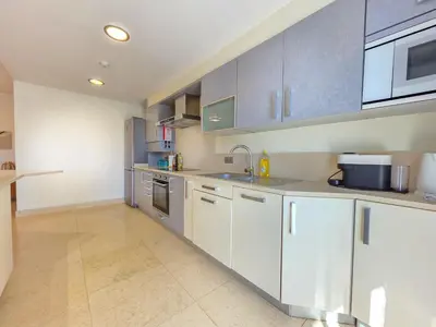 a kitchen with white cabinets and a sink at Fórum Madeira Residence in Funchal