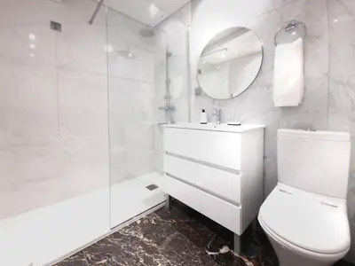 a bathroom with a toilet and a sink and a mirror at Fórum Madeira Residence in Funchal