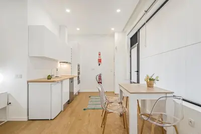 a kitchen with white cabinets and a table and chairs at Casa Isaurinha by ALMA Holiday Rentals in Caniço