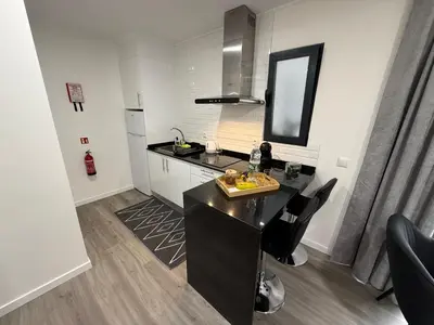 a kitchen with a black counter and a sink at Stay Lombinho in Porto da Cruz