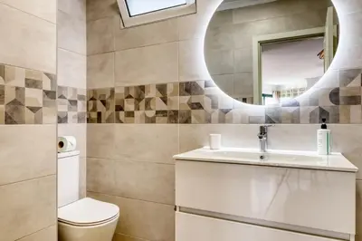 a bathroom with a toilet and a sink and a mirror at Funchal Panoramic View, a Home in Madeira in Funchal