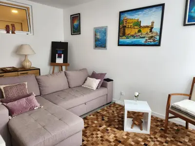 a living room with curtains and a white table at Santa Beatriz Apartment in Machico