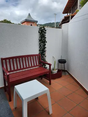 a red bench and a stool on a balcony at Santa Beatriz Apartment in Machico