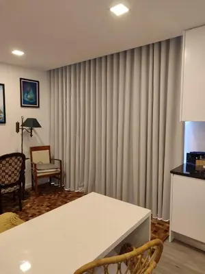 a living room with curtains and a white table at Santa Beatriz Apartment in Machico