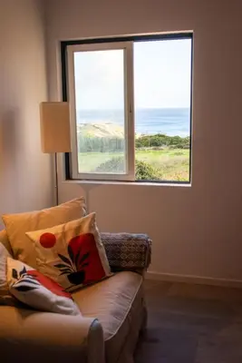 a living room with a couch in front of a window at Seaview Ensuite rooms in Sagres centre - Casa Maluka in Sagres