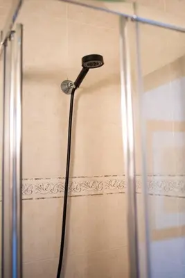 a shower with a shower head in a bathroom at Seaview Ensuite rooms in Sagres centre - Casa Maluka in Sagres