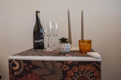 a bottle of wine and two glasses on a table at Seaview Ensuite rooms in Sagres centre - Casa Maluka in Sagres